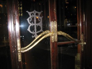 Brass door handle like an over-sized tilde - lovely interior